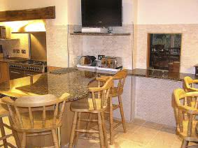 Luxurious kitchen with granite tops, marble tiles and oak furniture